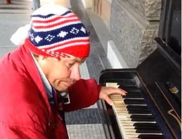 Policajt za klavírom má konkurenciu: Bezdomovec hrá v centre Prahy Vltavu